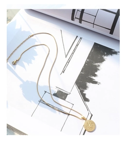 Detail of gold Libra pendant necklace with JUSTICE engraving on a magazine background