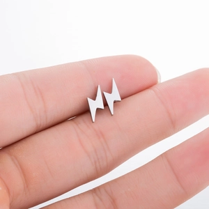 Minimalist stainless steel lightning bolt stud earrings shown on hand for size reference