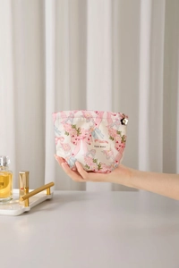 Close-up of pink floral cotton makeup bag with metal flower zipper and fabric label
