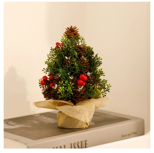Mini pine cone Christmas tree decoration with red berries and burlap base on books
