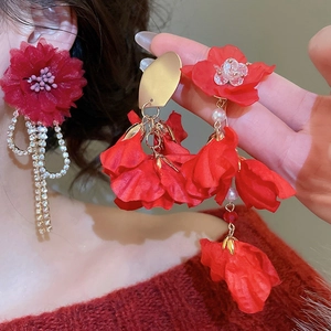 Macro view of vintage red satin flower earrings with sparkling rhinestone tassels and pearls