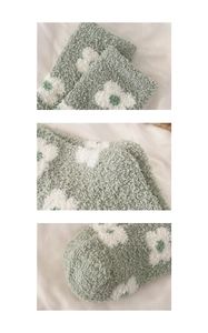 Detailed texture of mint green coral fleece socks with white flower pattern