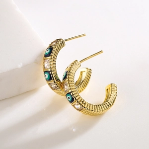 Golden C-shaped earrings with green evil eye and clear cubic zirconia insets