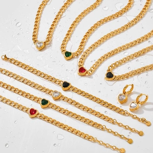 Flat lay of gold stainless steel jewelry sets with colorful heart zircon on water background