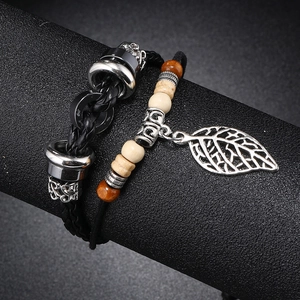 Detail of multi-layer beaded leather bracelet with hollow metal leaf charm and wooden beads