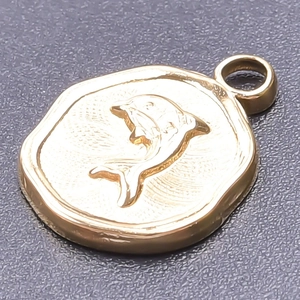 Detailed close-up of 18k gold-plated stainless steel dolphin pendant on grey surface