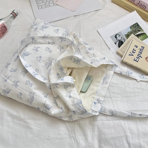 Detail of white canvas tote bag inner zip pocket and cute blue cat pattern print