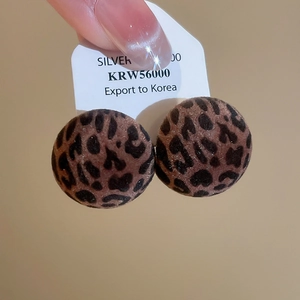 Detail of red leopard print flocked round stud earrings with silver needles for autumn
