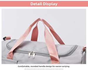 Close-up of the grey fitness bag featuring pink rounded handles and durable dual zippers