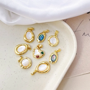 Elegant 18k gold-plated heart charms with natural shell inlay on a ceramic plate