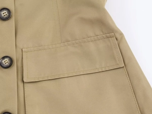 Detail der khakifarbenen Twilljacke mit Pattentasche, dunklem Knopf und feiner Naht