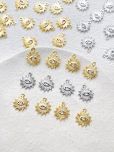 Macro shot of 14k gold-plated evil eye sunburst charms with sparkling zircon stone