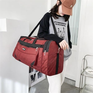 Deep red nylon travel bag with adjustable shoulder strap and large side zipper pocket