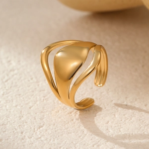 Detail view of a 18k gold minimalist stainless steel open ring on a textured surface