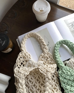 Handmade crochet tote bags with drawstring liners on a rustic wooden table setting
