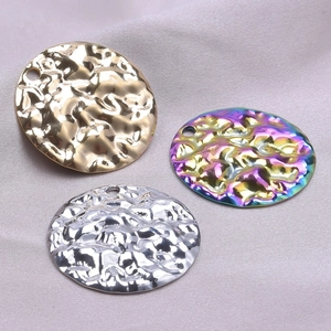 Detailed macro view of three hammered metal pendants in gold, silver, and rainbow finishes