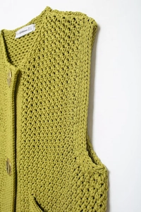 Detailed close-up of olive green knit vest showcasing the thick yarn and ribbed texture