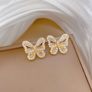 Close-up of elegant gold butterfly stud earrings with sparkling crystals on jewelry box