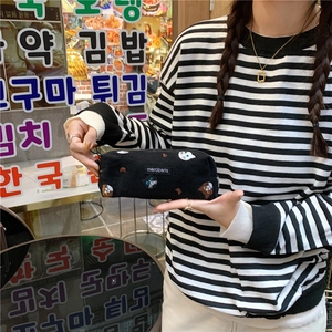 Close-up of black canvas pencil case with cute cartoon cat patterns and woven label
