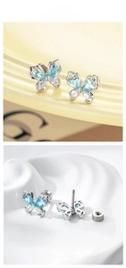 Macro detail of blue butterfly cartilage studs with silver finish and screw-back design