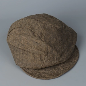 Detail of distressed linen newsboy cap featuring multi-panel stitching and vintage texture