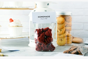 Close-up of festive gingerbread man and star cookies in red homemade gift packaging