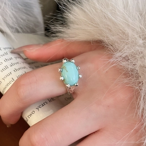 Detail view of oval blue turquoise stone on textured silver band with vintage style