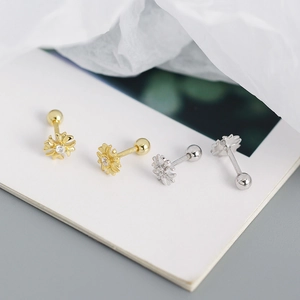 Macro shot of silver and gold sunflower screw back earrings with crystal centers