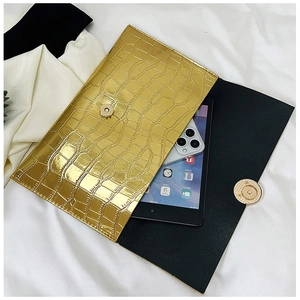 Detail of gold stone texture envelope clutch bag holding a smartphone and small tablet