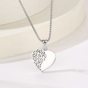 Détail macro du collier cœur en argent avec motifs de vigne ajourés et poli miroir brillant