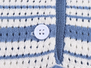 Detailed close-up of blue and white striped knitwear with hollow texture and white buttons