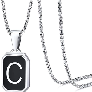 Detail of silver box chain with black square pendant featuring white letter C engraving