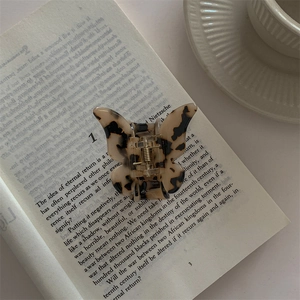 Close-up of tortoise shell butterfly hair claw clip on an open vintage book