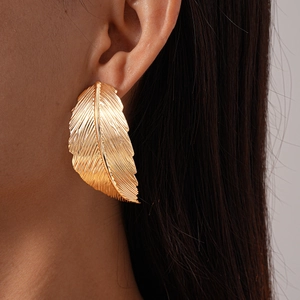Detailed macro view of gold leaf earring featuring fine radial texture and matte finish