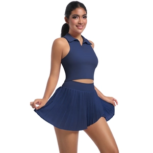 Dettaglio del crop top polo blu navy e gonna da tennis a pieghe per prestazioni sportive