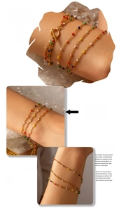 Detail view of multi-color enamel beads on a layered gold plated stainless steel bracelet