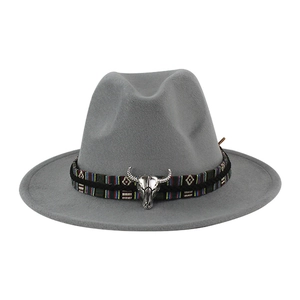 Dettaglio cappello fedora grigio con fascia etnica intrecciata e testa di toro argento