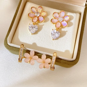 Elegant gold-plated pink resin flower earrings with heart zircon pendants on green velvet