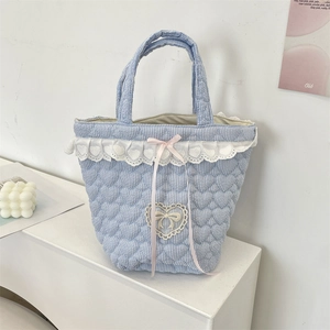 Dettaglio della borsa trapuntata a righe blu con pizzo bianco e fiocco rosa decorativo