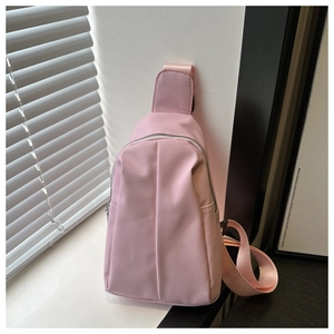 Detailed view of pink nylon crossbody bag with stylish vertical pleated design and zipper