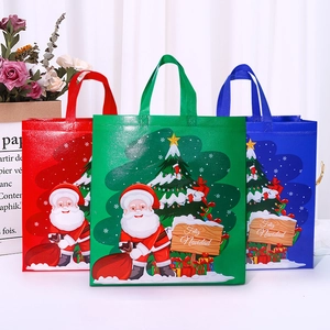 Three festive Christmas non-woven gift bags in red, green, and blue with Santa prints