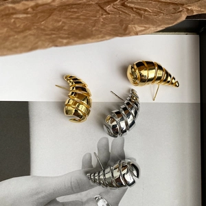 Artistic layout of gold and silver spiral earrings with polished metallic finish