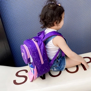 Detailed side view of a purple rocket-shaped toddler backpack with pink decorative wings
