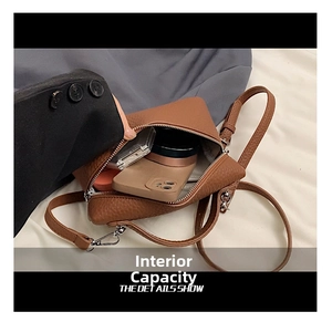 Internal capacity of brown pebble leather handbag showing smartphone and makeup items