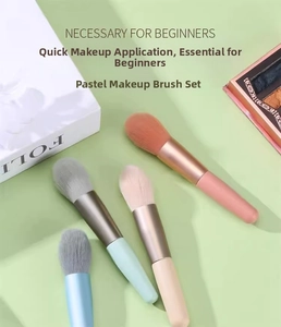 Detail of four mini candy-colored makeup brushes with soft bristles and matte metal tubes