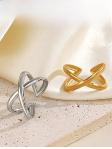 Detailed close-up of X-shaped cross rings in gold and silver finishes on silk
