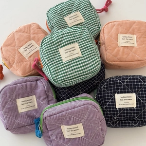 Detail of colorful checkered quilted cotton storage pouches with diamond stitching