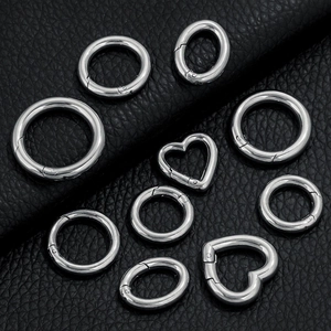 Close-up of assorted silver stainless steel spring rings and heart carbines on leather
