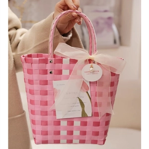 Detail of pink and white woven gift basket with pearls and a Good Luck tag