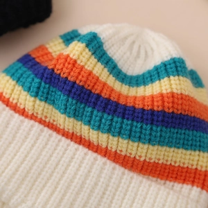 Detailed view of the multi-colored striped knit pattern and thick yarn texture of the baby hat